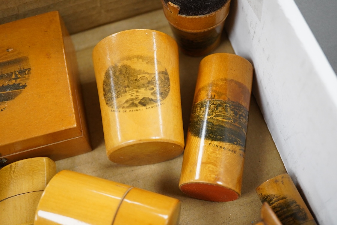 A collection of Scottish mauchline ware boxes, a pin cushion, beaker and a photo frame containing black and white topographical photos